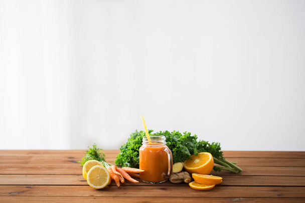 glass jug of carrot juice, fruits and vegetables - Фото, изображение