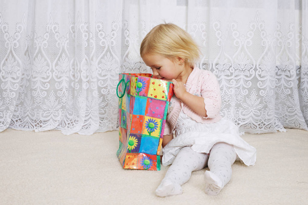 little girl looking into the shopping bag - Foto, Bild