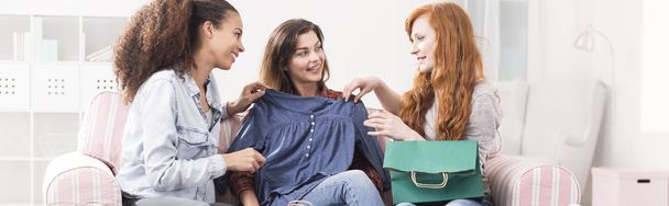 Woman holding new blouse chatting - 写真・画像
