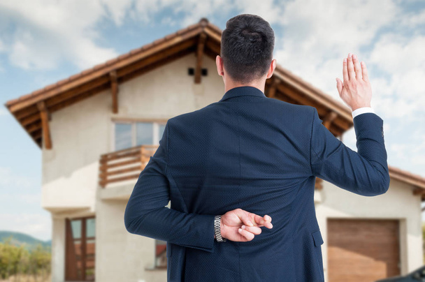Vue arrière de l'agent immobilier masculin avec doigt croisé
 - Photo, image