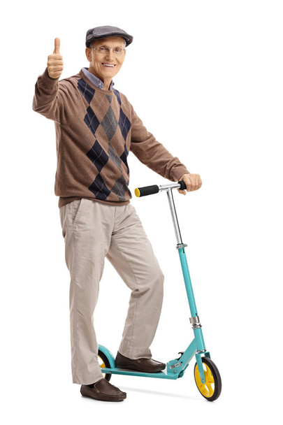 Mature man posing with scooter and making thumb up - Foto, afbeelding