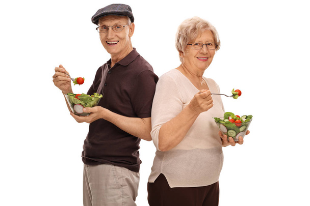 Mature man and woman eating salads - Foto, afbeelding