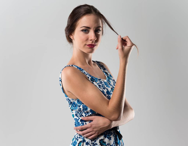 Красива модель жінка позує в студії з блакитним платтям
 - Фото, зображення