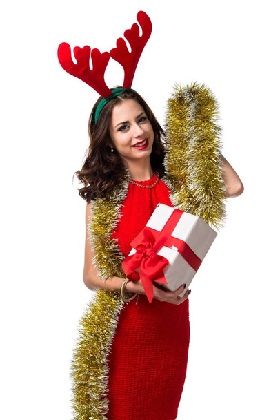 Mooie jonge vrouw met kerst gift en rendieren geweien - Foto, afbeelding