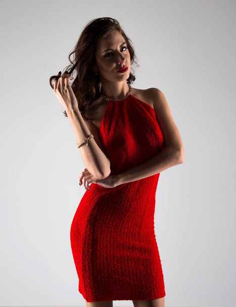 Γυναίκα νεαρό μοντέλο ποζάρει με σέξι κόκκινο φόρεμα - Φωτογραφία, εικόνα