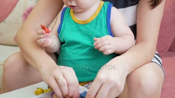 Beautiful baby boy sculpts the clay with his mother at home. Together having fun and making animal figurines. child education concept - Footage, Video