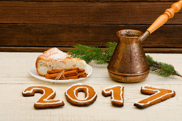 Figura em 2017 de pão de gengibre, panelas, ramo de abeto e torta de maçã em uma mesa de madeira
 - Foto, Imagem