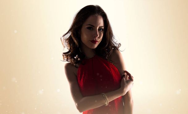 若いモデルの女性セクシーな赤いドレスでポーズ - 写真・画像