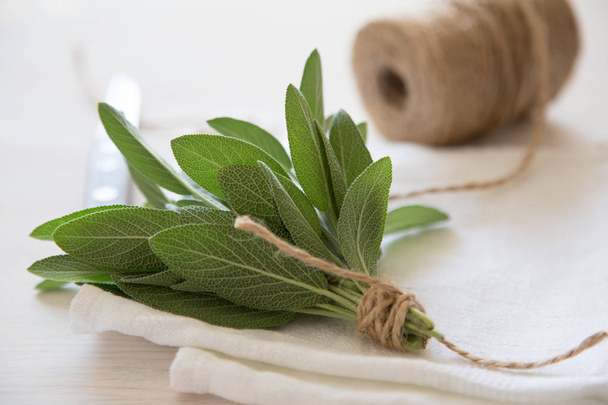 A bunch of fresh sage on light wooden table. Selective focus - Photo, Image