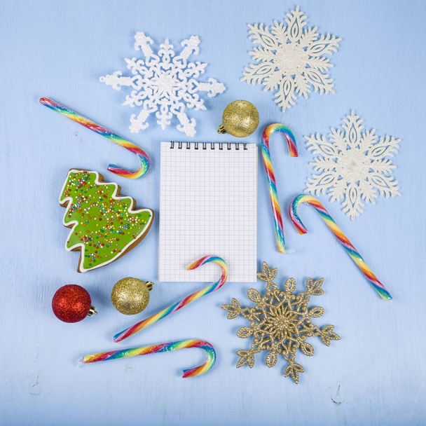 Notebook, candies and gingerbread on a blue wooden background. C - Foto, Bild
