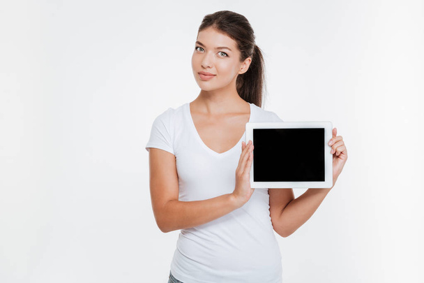 Woman holding digital tablet and showing the display - 写真・画像