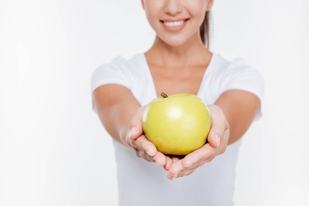Cropped picture of young cheerful woman holding apple - Foto, Imagen