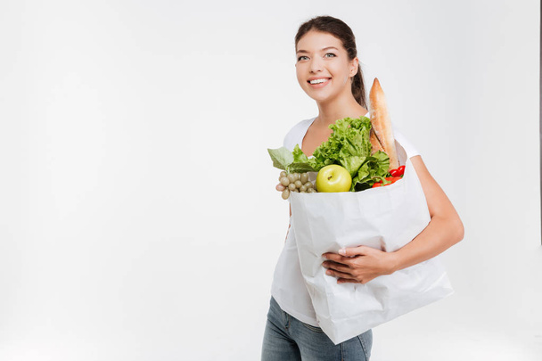 Happy woman holds fruit and vegetable - Fotoğraf, Görsel