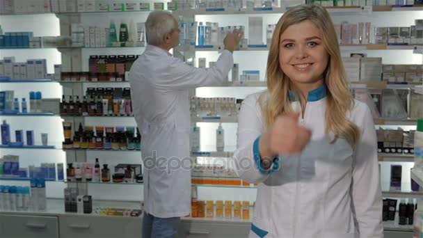 Vrouwelijke apotheker toont haar duim omhoog bij de drogisterij - Video