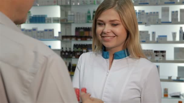 El cliente recibe ampolla de píldoras del farmacéutico en la farmacia
 - Imágenes, Vídeo