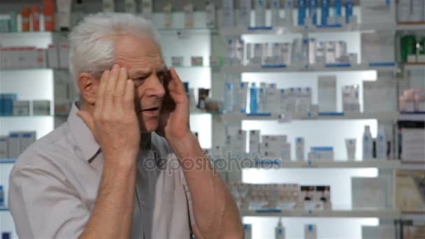 männliche Kundin kommt mit Kopfschmerzen in die Drogerie - Filmmaterial, Video