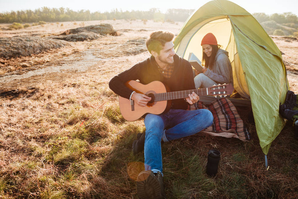 Couple with guitar in tent - Zdjęcie, obraz