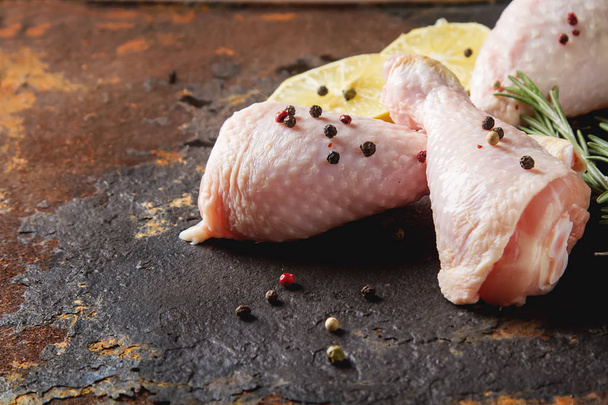 Chicken legs with rosemary, pepper and lemon. Dark background. L - Фото, изображение