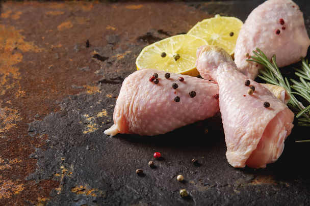 Chicken legs with rosemary, pepper and lemon. Dark background. L - Фото, изображение