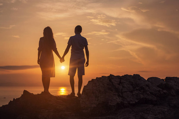 Silhouette of Love couple standing on  cliff - Foto, afbeelding