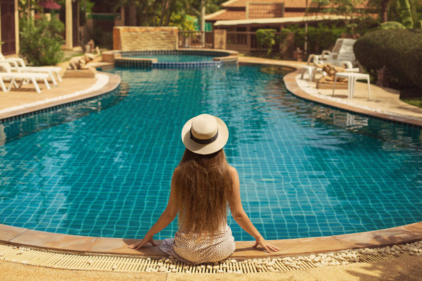 woman sitting near the swimming pool - Foto, Bild