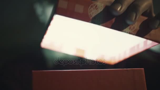 Close up of surprised man opening luminous gift box at night Christmas Eve time - Materiaali, video