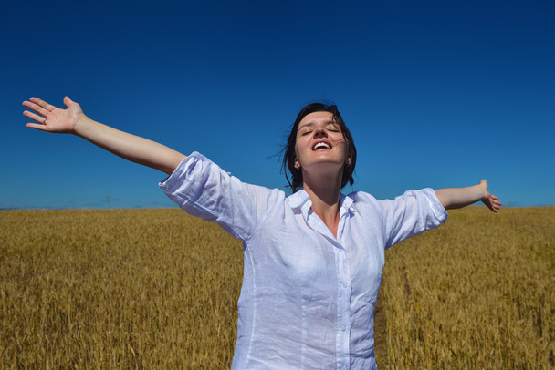 Молодая женщина в пшеничном поле летом - Фото, изображение