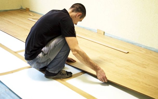 Prosessi asentaa laminaatti puinen lattialle
  - Valokuva, kuva