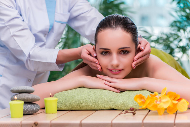 Jonge vrouw tijdens massage sessie - Foto, afbeelding