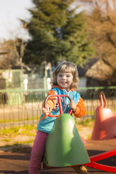 klein meisje spelen op speelplaats - Foto, afbeelding