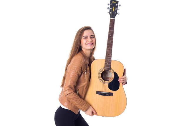 νέα γυναίκα που κρατά μια κιθάρα - Φωτογραφία, εικόνα