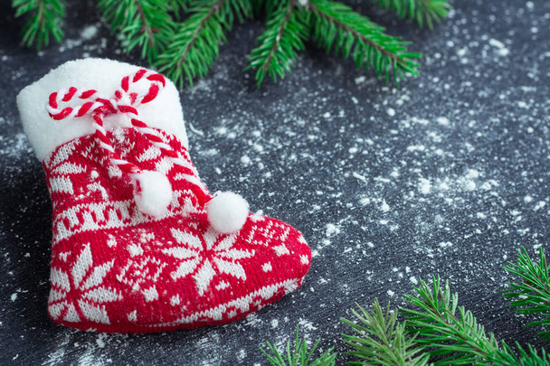 Χριστουγεννιάτικη κόκκινη κάλτσα σε χιονισμένα μαύρο φόντο με έλατα br - Φωτογραφία, εικόνα