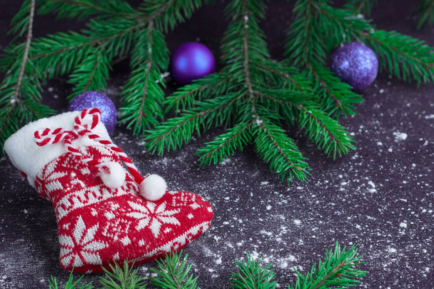 Christmas red stocking on snowbound black background with purple - Photo, Image
