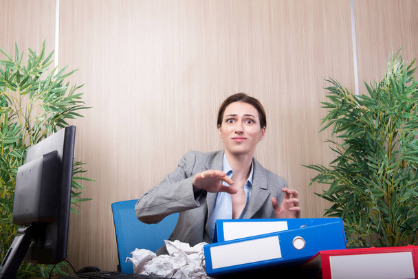 Woman under stress tossing papers in the office - Фото, зображення