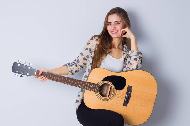 若い女性はギターを抱えて - 写真・画像