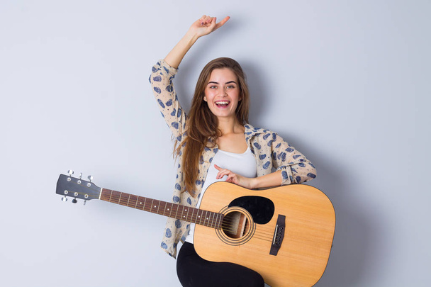 Fiatal nő tartja a gitár - Fotó, kép