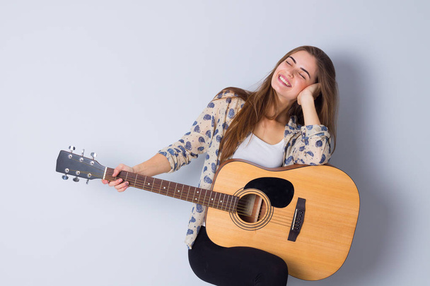 mladá žena drží kytara - Fotografie, Obrázek