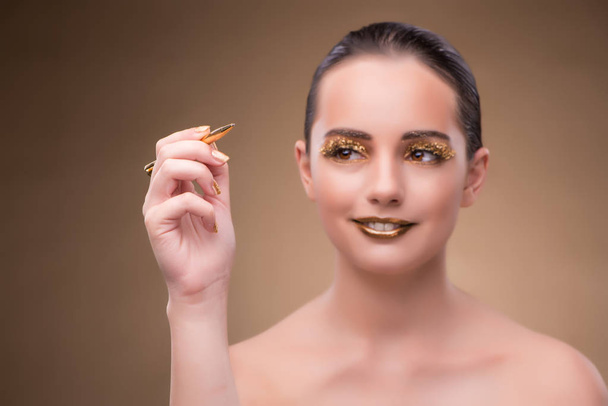 Mujer con pluma dorada en concepto de moda
 - Foto, Imagen
