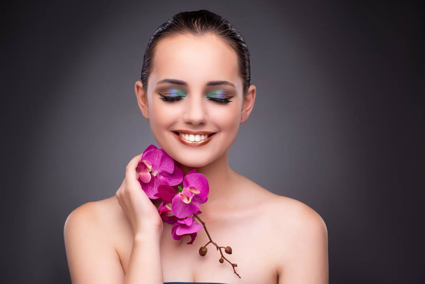 Beautiful woman with orchid flower - Foto, afbeelding