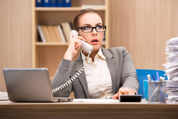 Деловая женщина в состоянии стресса из-за слишком много работы в офисе
 - Фото, изображение