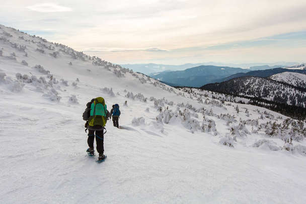 Homem caminhando em montanhas de inverno antes de trovoada
 - Foto, Imagem