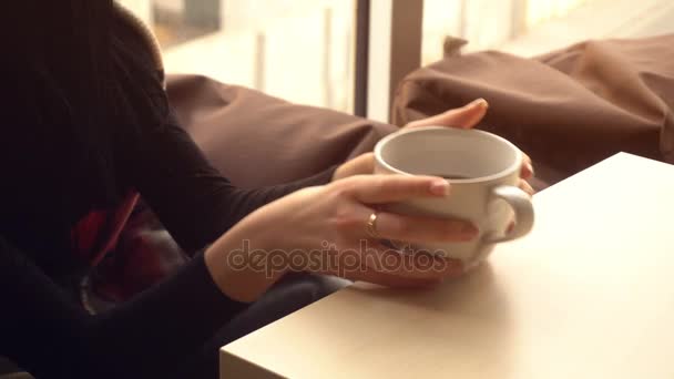 beautiful brunette takes the cup and drinks tea - Footage, Video