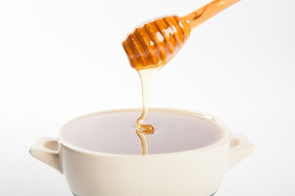 Juicy honey in a cup and spoon - 写真・画像