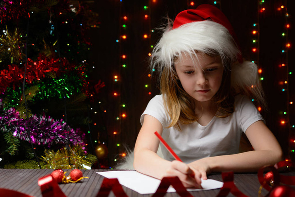 Chica escribió en lápiz rojo una carta a Santa Claus
 - Foto, imagen