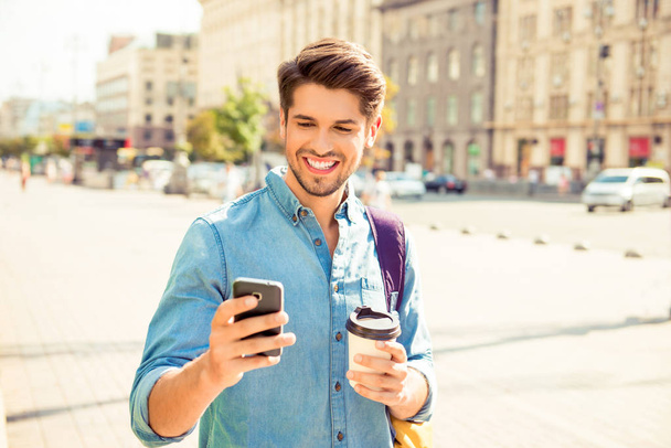 Happy guy having walk in the city and typing sms - Foto, immagini
