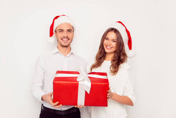 Happy man and woman holding big red christmas gift - Foto, Bild
