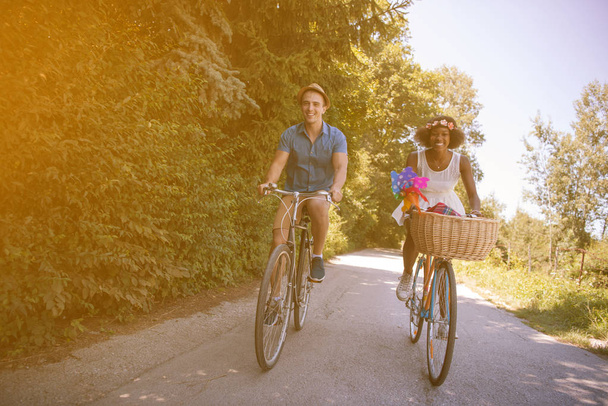Giovane coppia multietnica che fa un giro in bicicletta nella natura
 - Foto, immagini