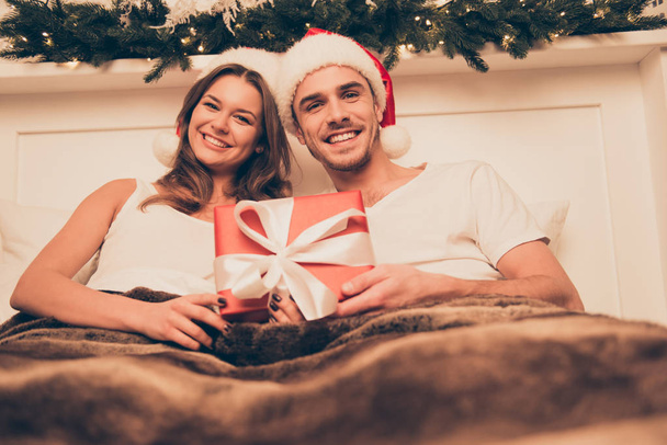Portrait of happy young family lying in ded on christmas holiday - Photo, Image