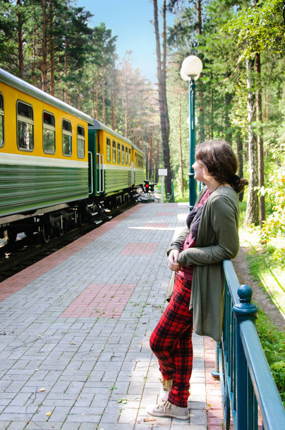 Young woman standing on railway station - Zdjęcie, obraz