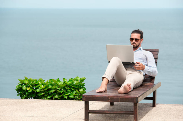 Бизнесмен в костюме с ноутбуком на пляже
 - Фото, изображение